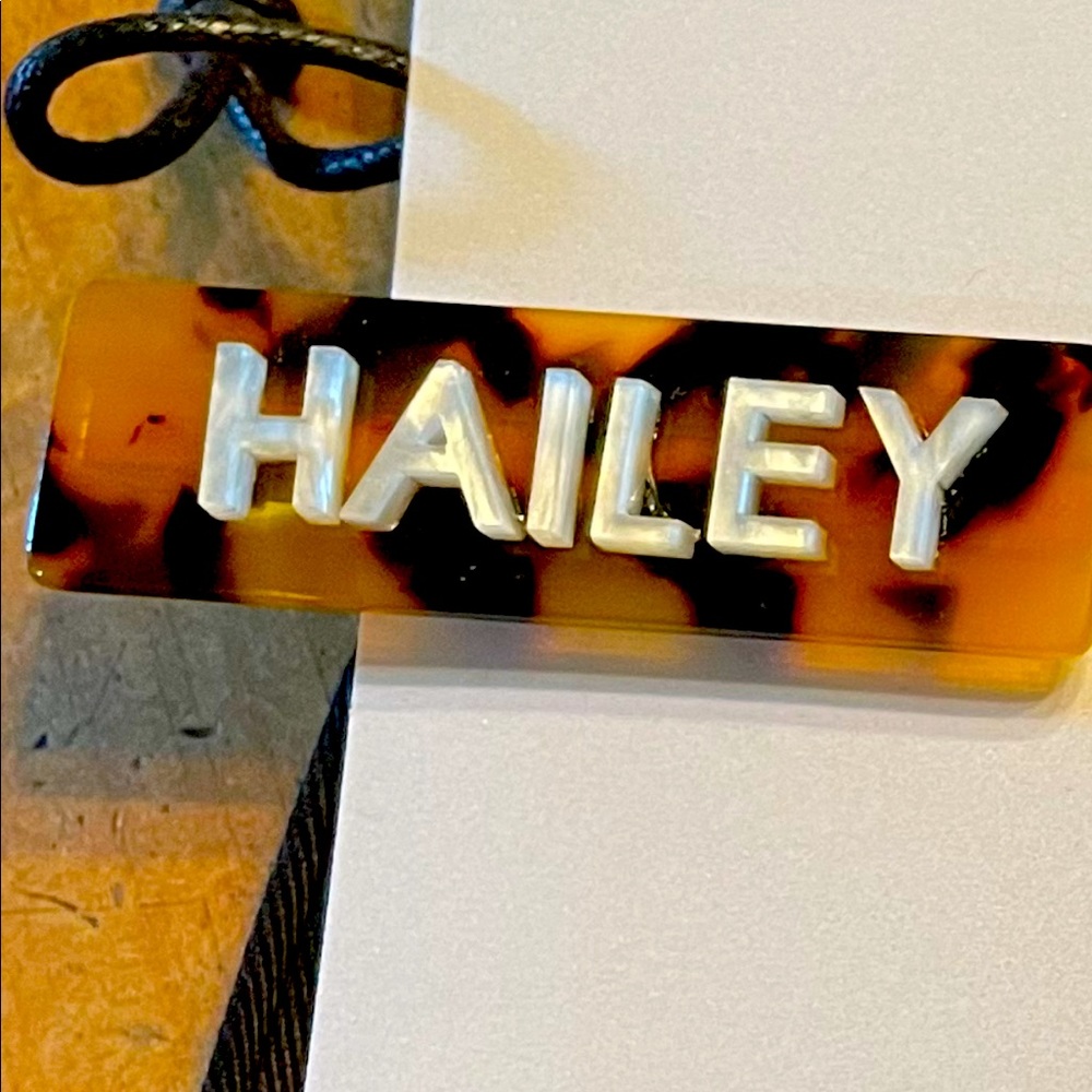 set of 2 Baublebar hair clips. One with initial “H” one with name “Hailey”